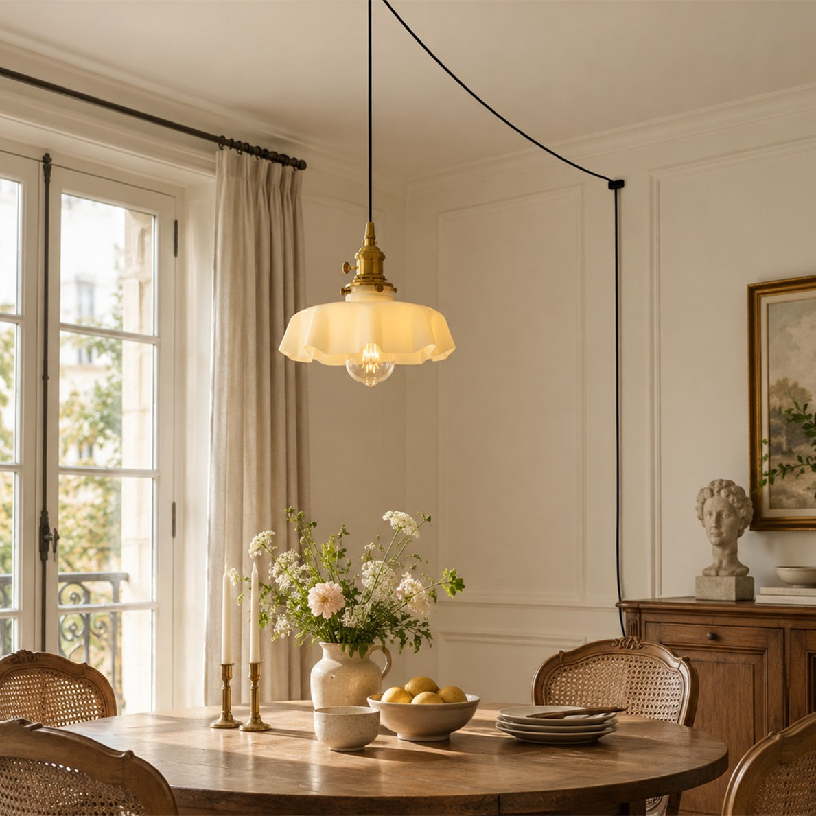 Lámpara colgante de cristal con forma de flor blanca sobre una mesa de comedor de madera.