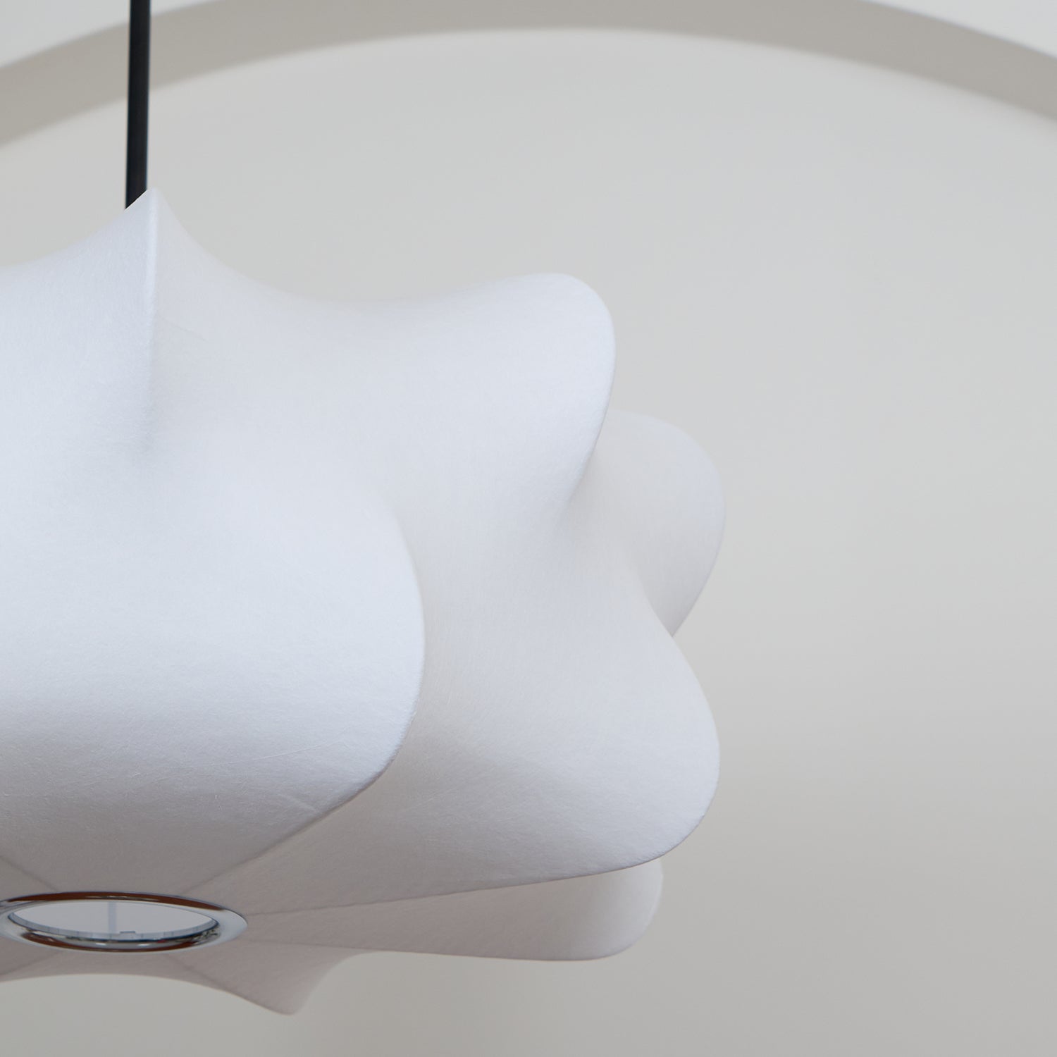 Pendant shade viewed from below, revealing flowing contours and a circular lower opening