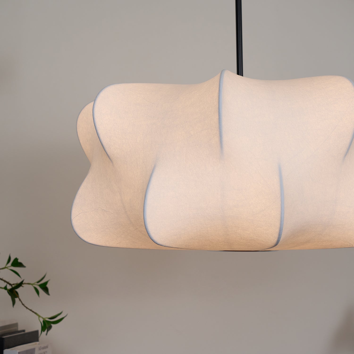 Illuminated sculptural pendant with flowing curves and a warm glow