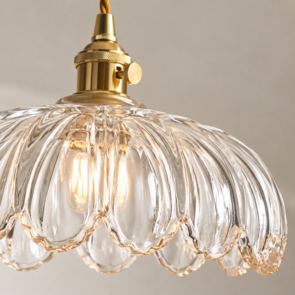 Close-up of clear fluted flower glass and brass holder