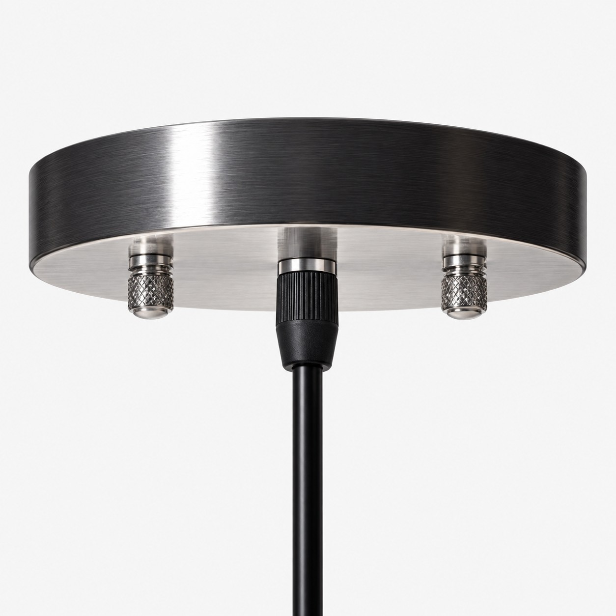 Dark round metal ceiling canopy with visible fasteners and black pendant cord
