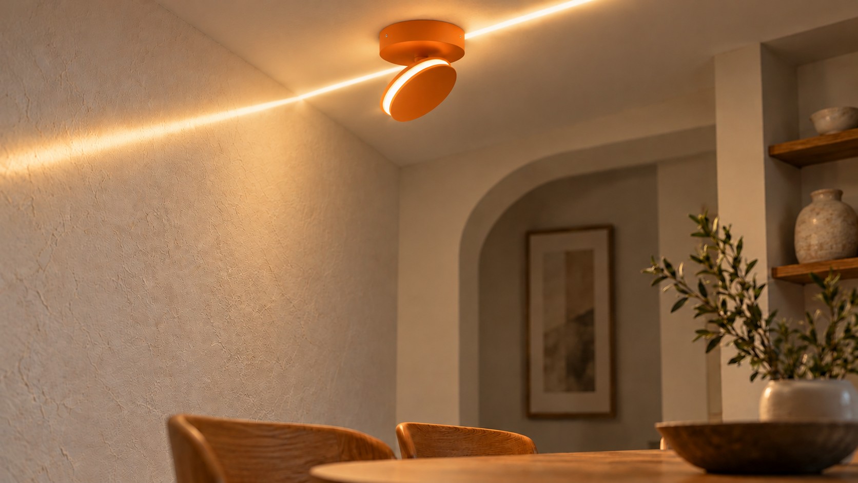 Pomarańczowa lampa ścienna SPECTRA skierowana ku górze, rzucająca ciepłą poświatę na sufit