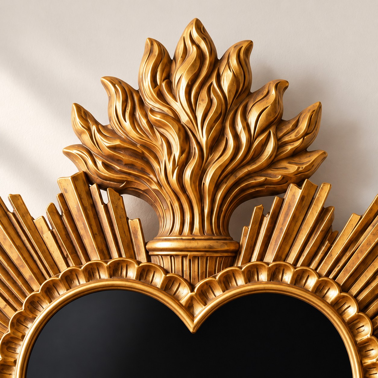 Close-up of the gilded sacred heart mirror crest and sunburst frame