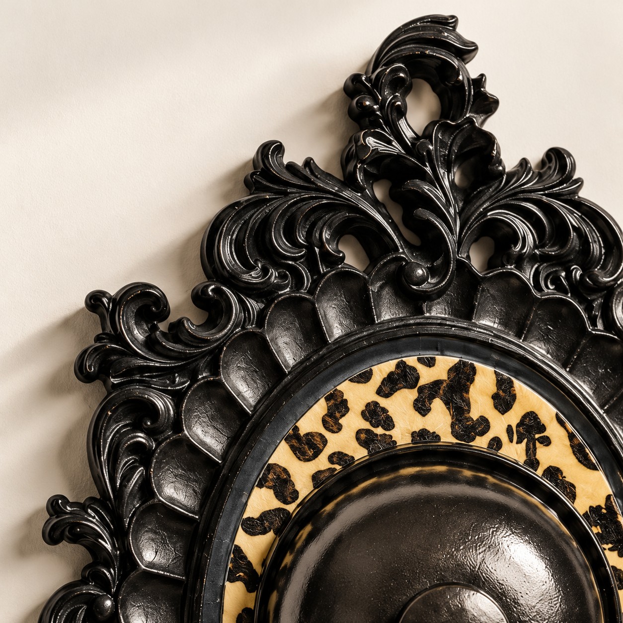 Crête de scroll noir brillant au-dessus d’un anneau léopard crème