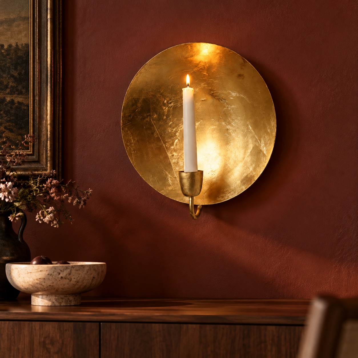 Bougeoir mural rond en feuille d'or au-dessus d'une console en bois; intérieur illustratif